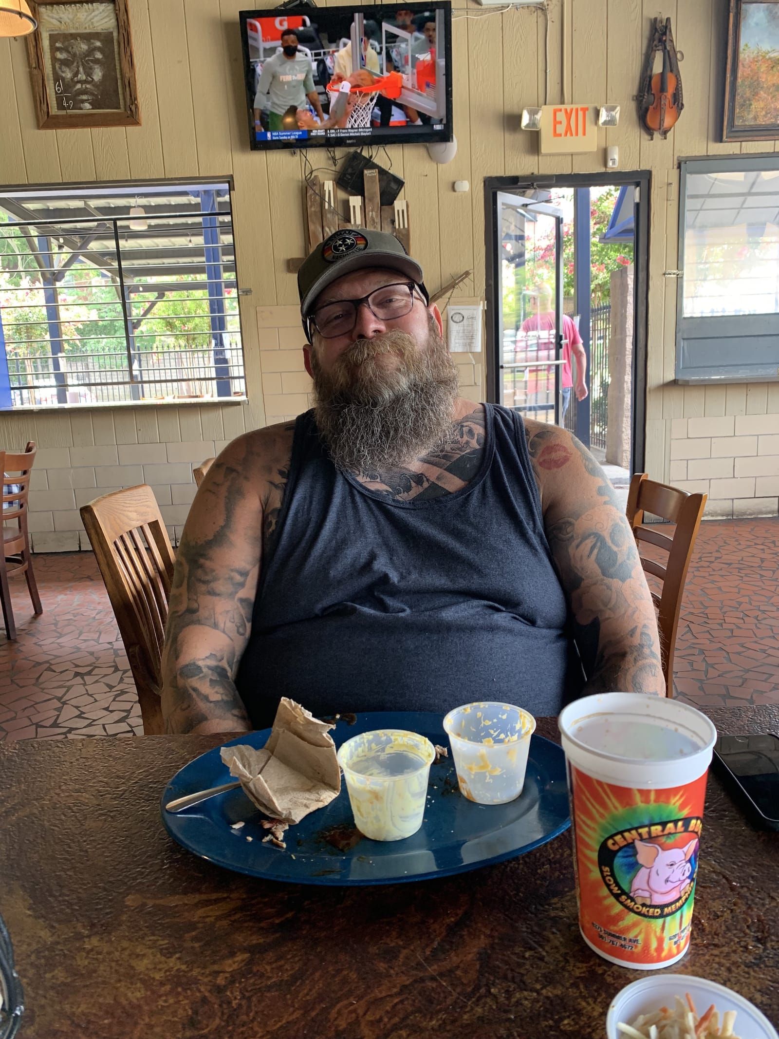 Mike with a content look on his face, sitting at the table with an empty plate in front of him.