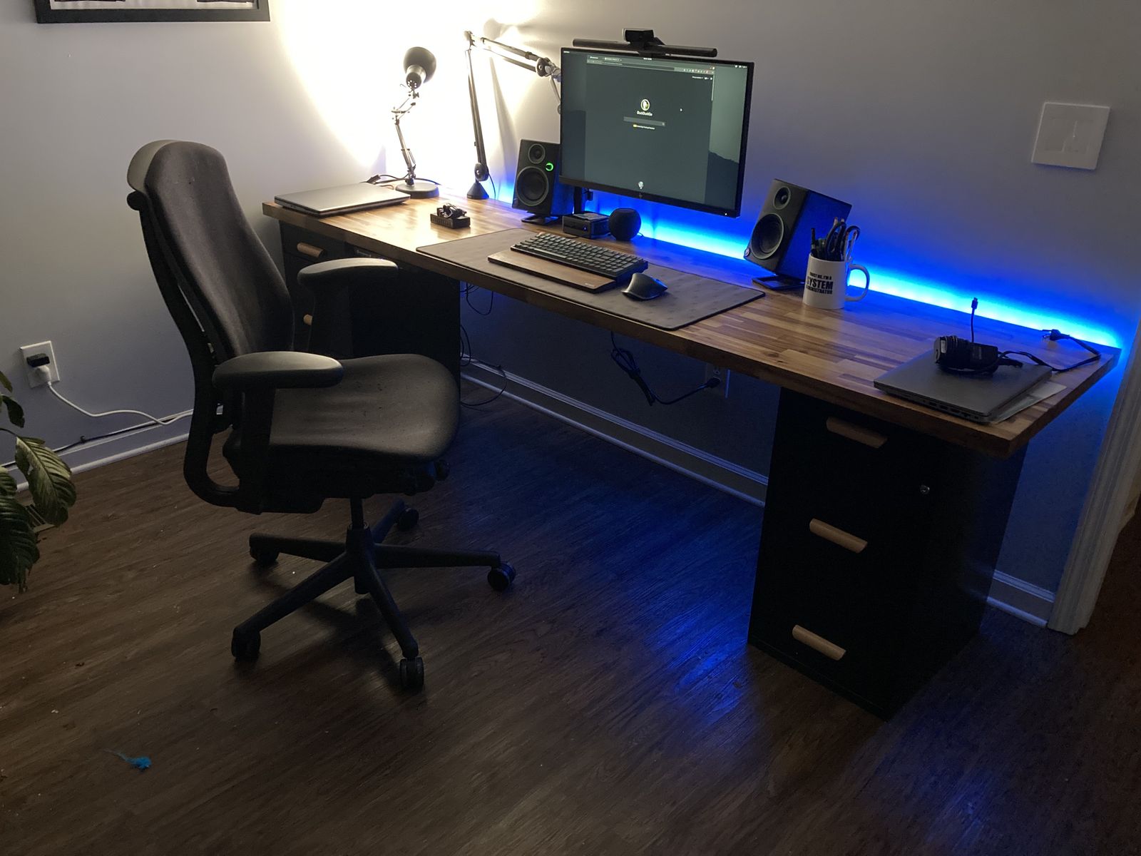 Wood computer desk with RGB lights and a desktop computer displayed.