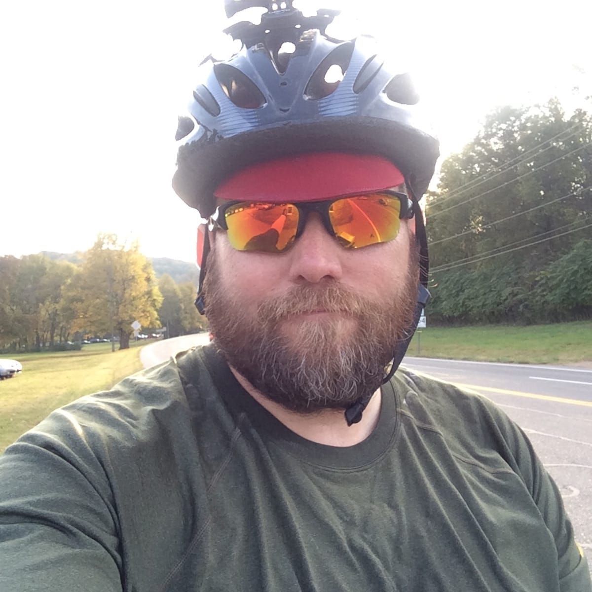 Selfie of Mike wearing a green shirt and yellow Oakley glasses. 