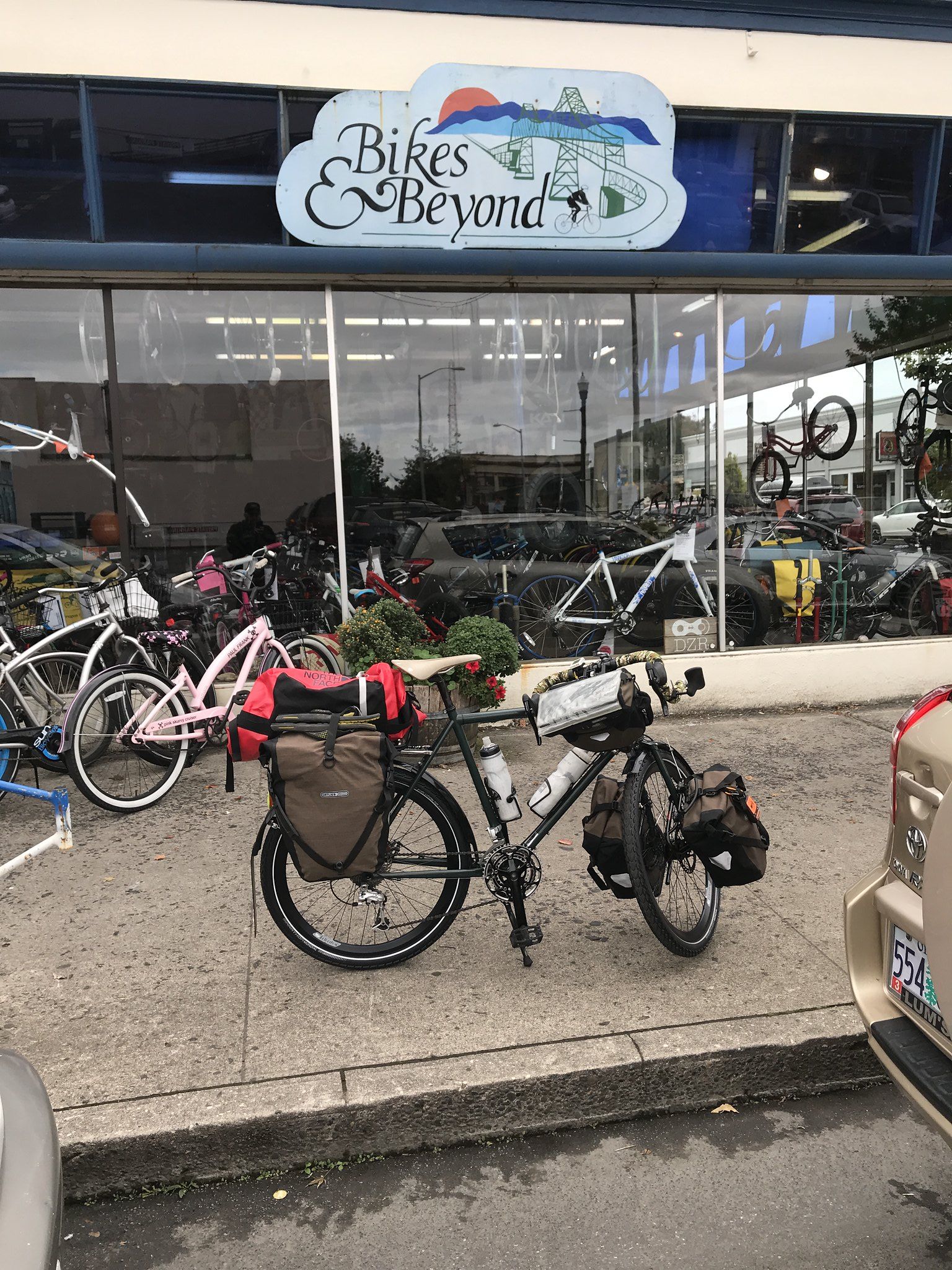 Tank bicycle in front of the bike shop fully loaded and waiting to leave.