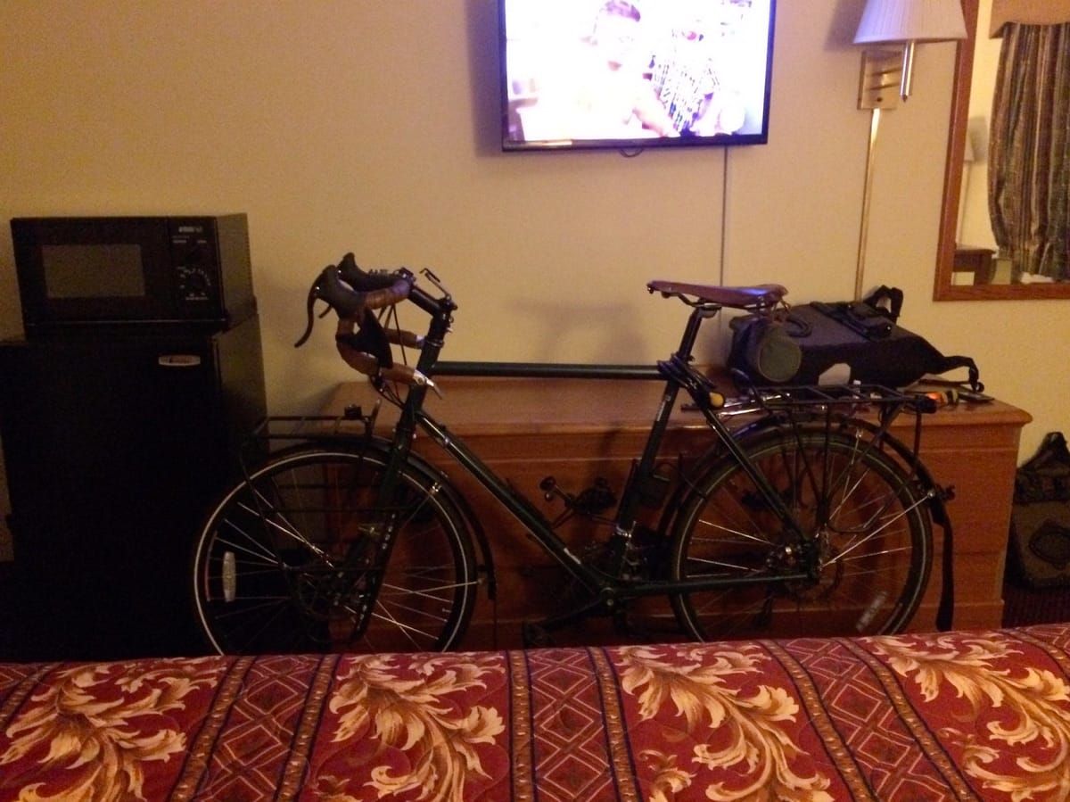 Unloaded touring bicycle in the motel room.