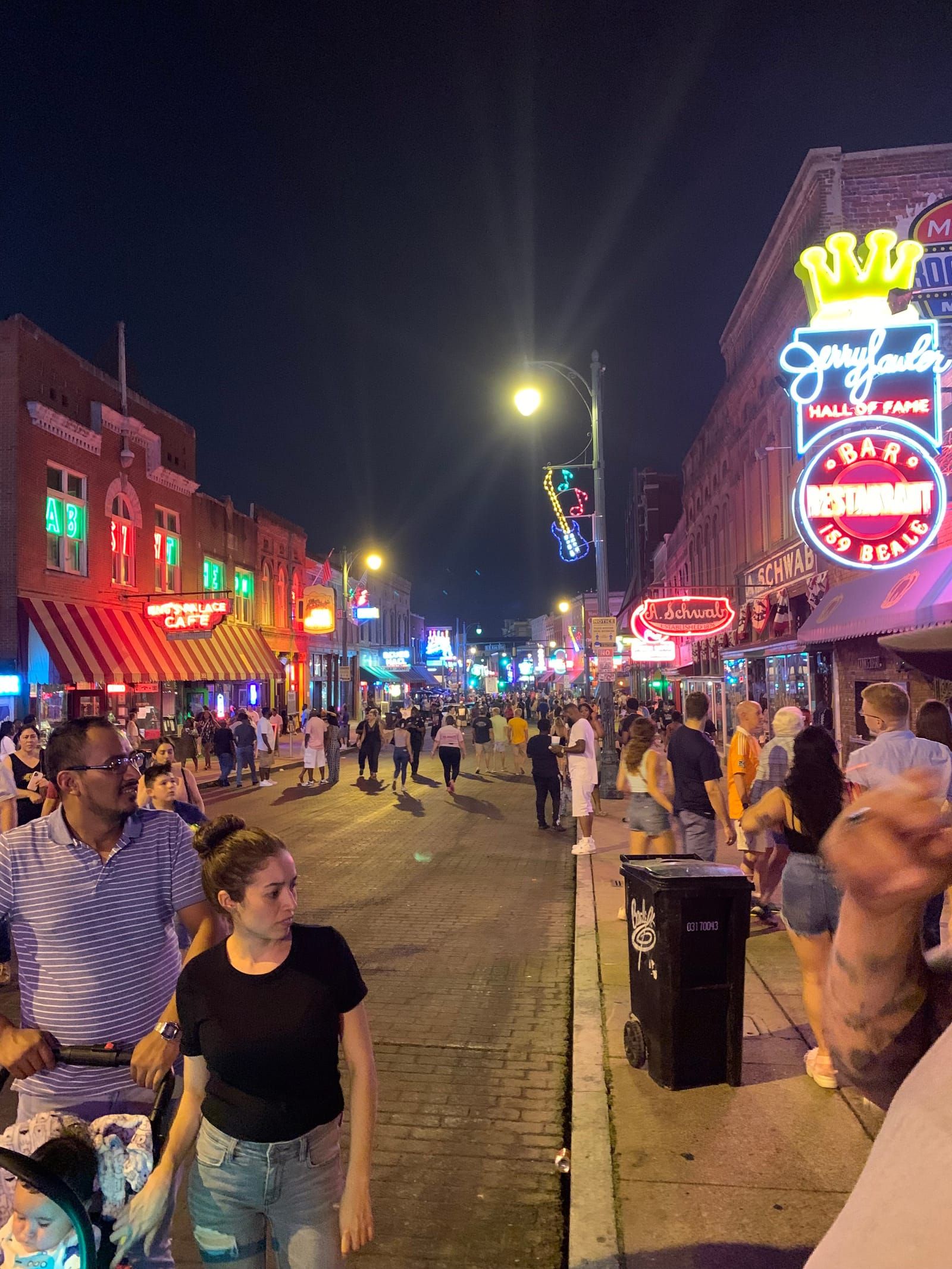 A busy Beale Street in Memphis. Many pedestrian mingle on this warm night.