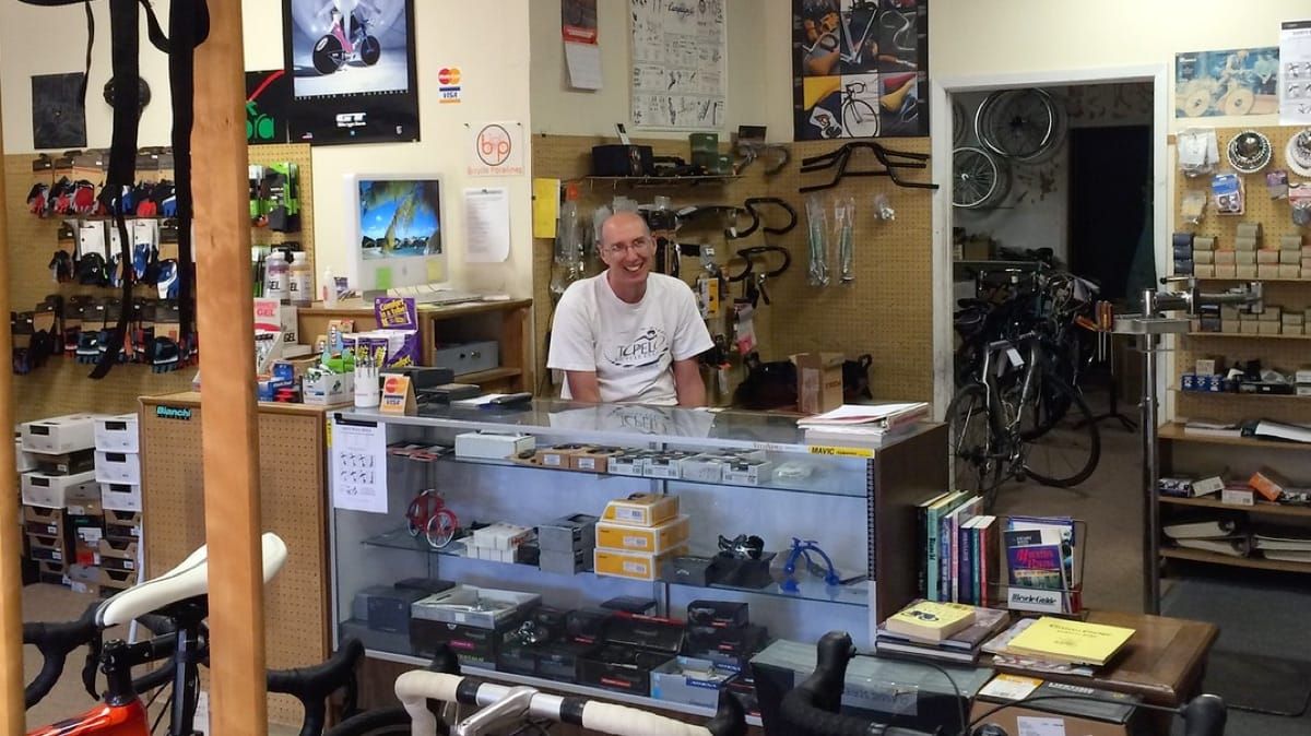 Bryan the bike mechanic, smiling as he sits at his desk.