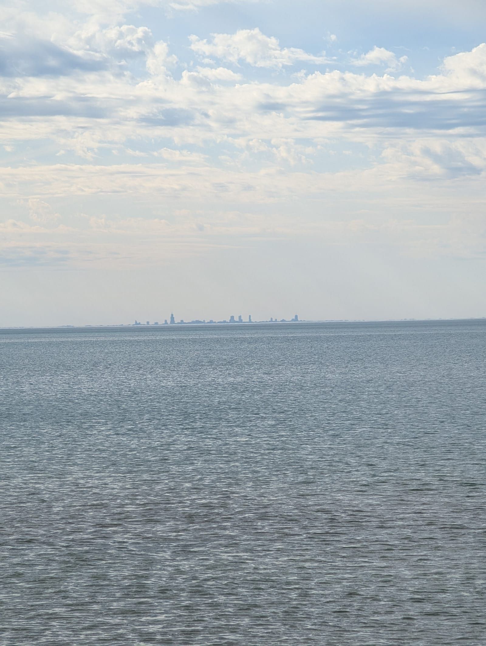 A photo of Lake Michigan. Chicago high rises can been in the distance, across the lake.