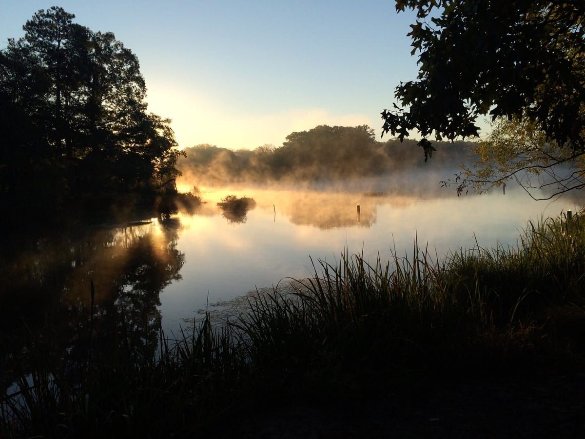Morning mist raising from the lake as the sun comes up.