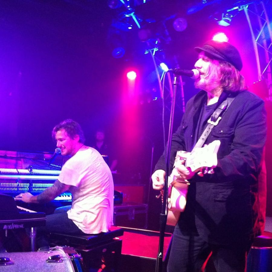 Butch Walker performing on stage, playing the piano with Kevn playing guitar.