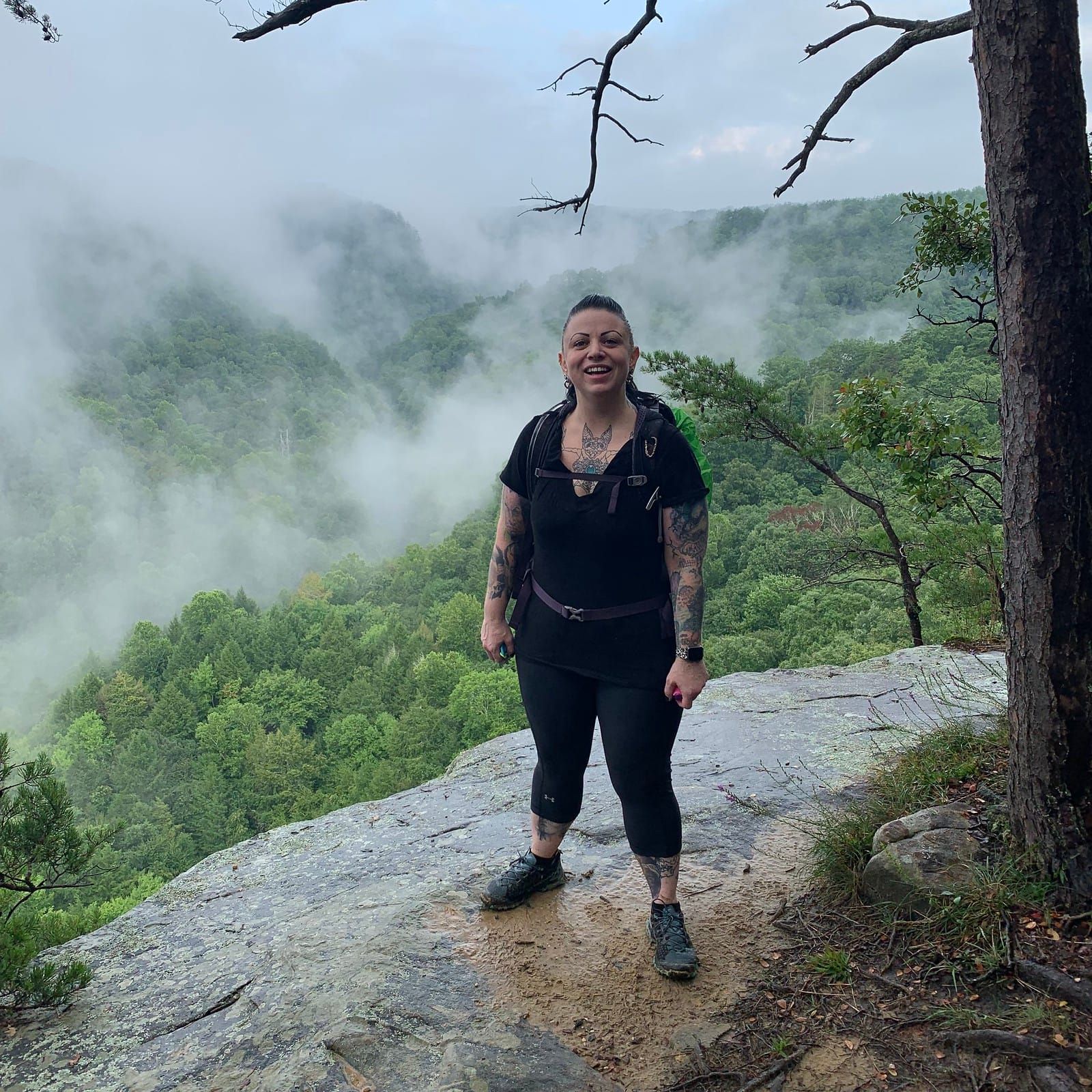 Photo of Meredith smiling on top of a bluffs.
