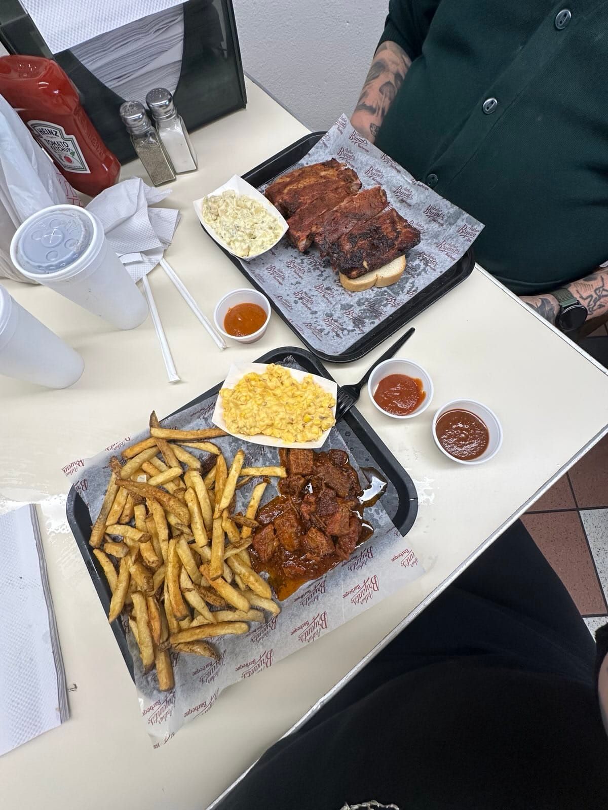 Photo of food. Michael has spare ribs and Rachelle has burnt ends. Both have sides.