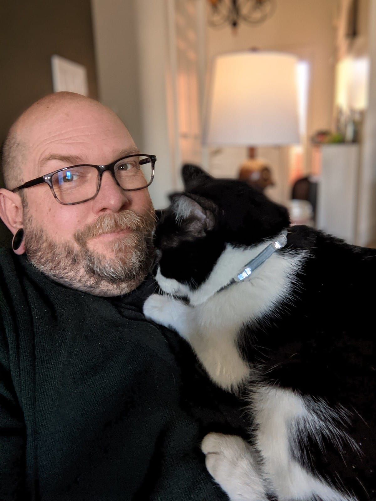 Oliver sits on Mike's chest as he looks at the camera.