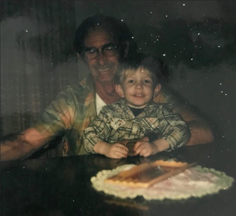 Dee holding a 1 year old Michael in his lap.