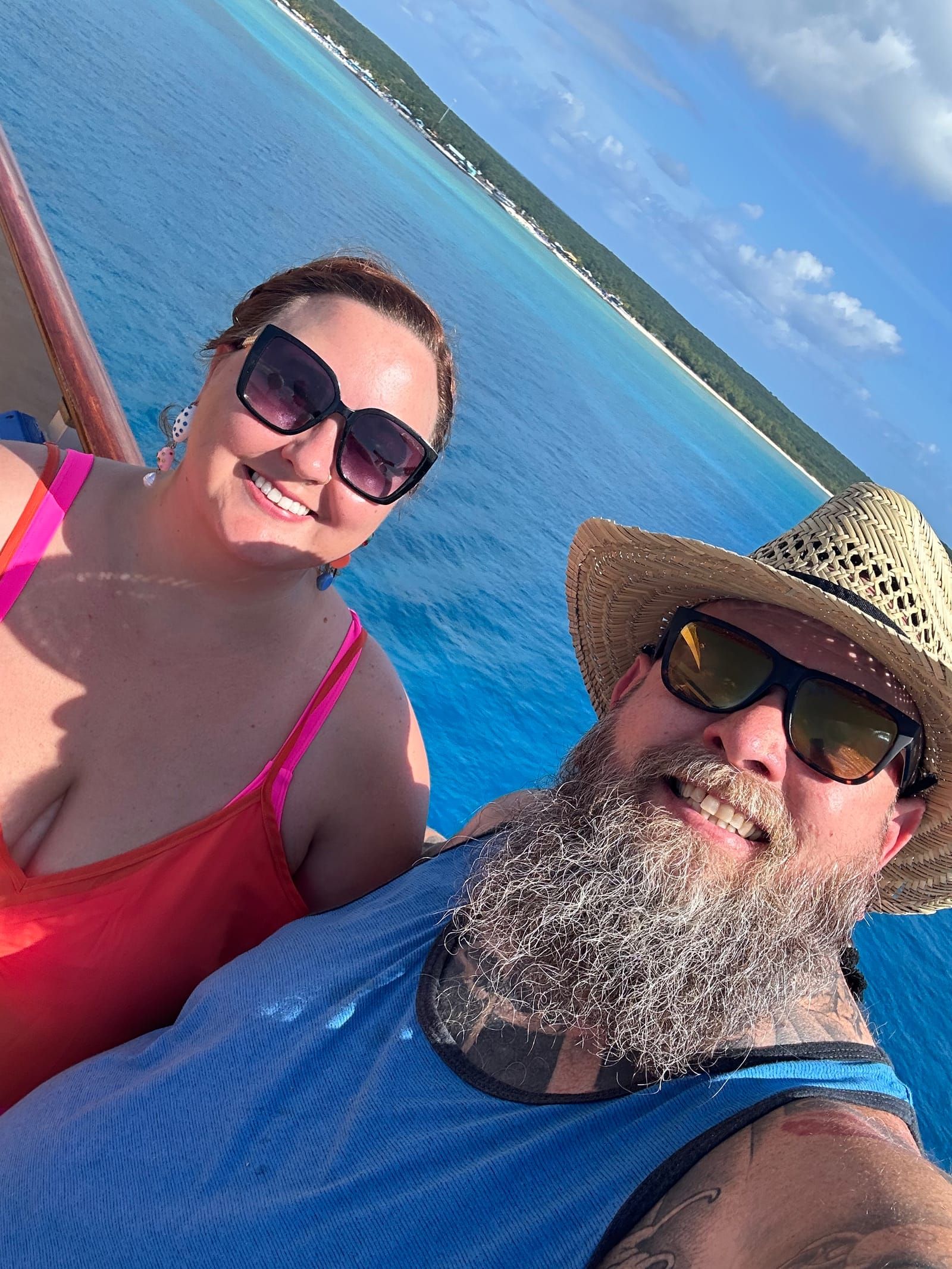 Selfie of Rachelle and Michael on the boat with a Princess Cays beach in the background.