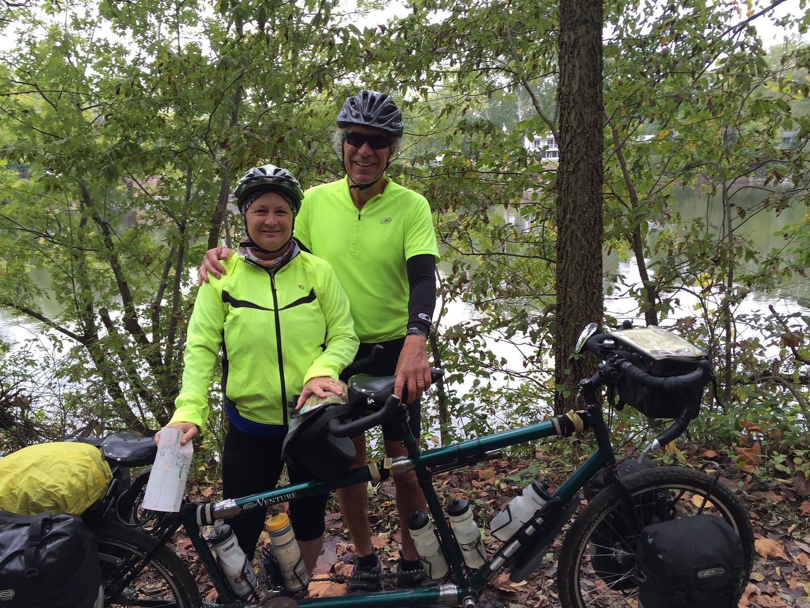 Two cyclists with bright yellow cycling jerseys and helmets.