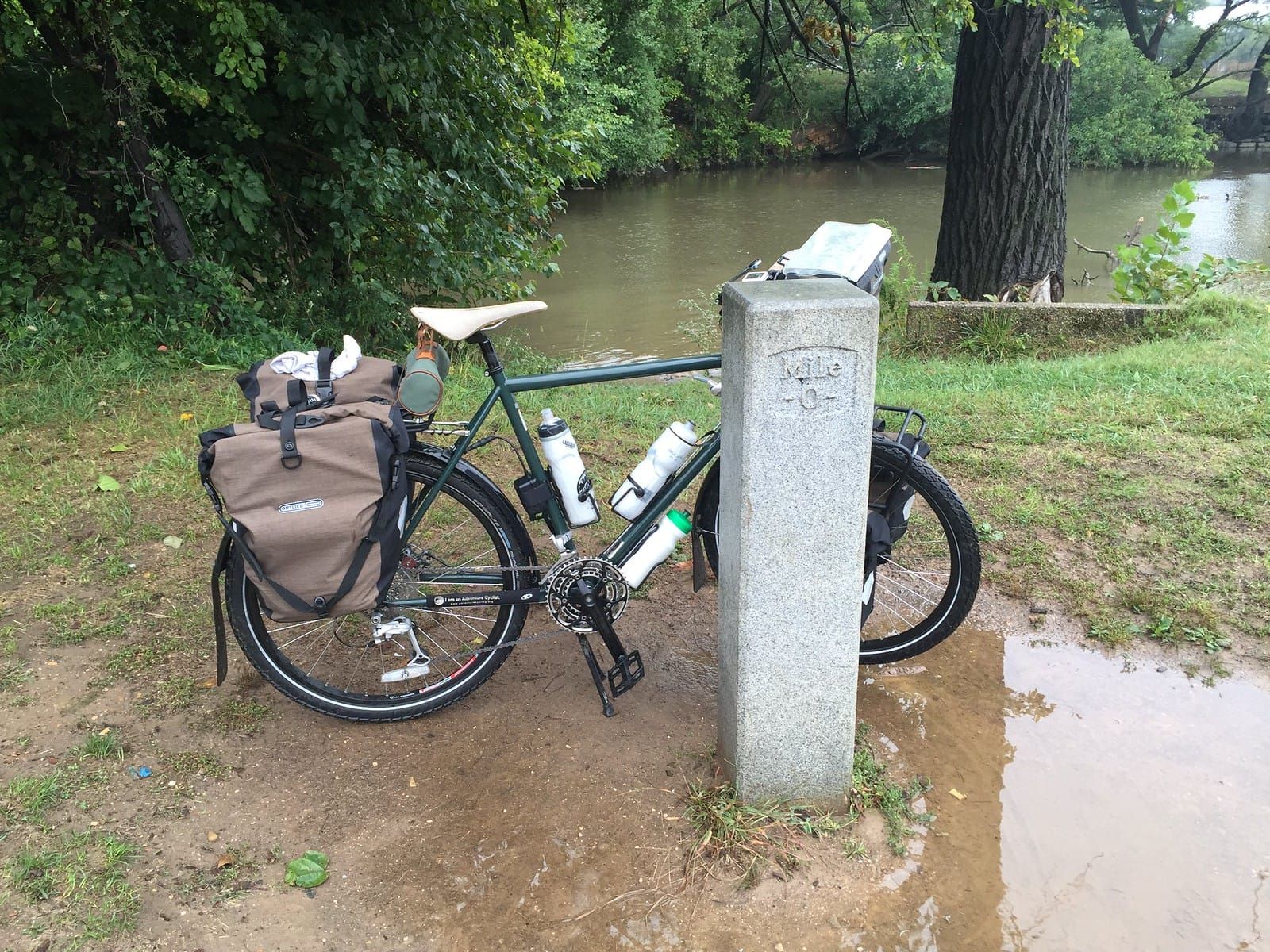 Fully loaded touring bicycle standing next to mile 0 mile marker for the C&O trail.