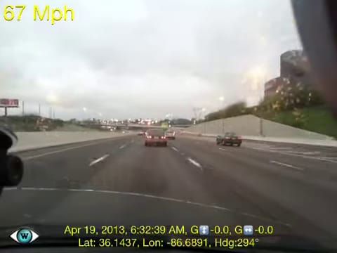 Dashcam view through a car windshield on a multi-lane highway under an overcast sky. A 67 Mph speed overlay sits top-left, a red sedan and a pickup truck are on the road ahead, and a GPS timestamp overlay reads April 19, 2013 near Nashville.