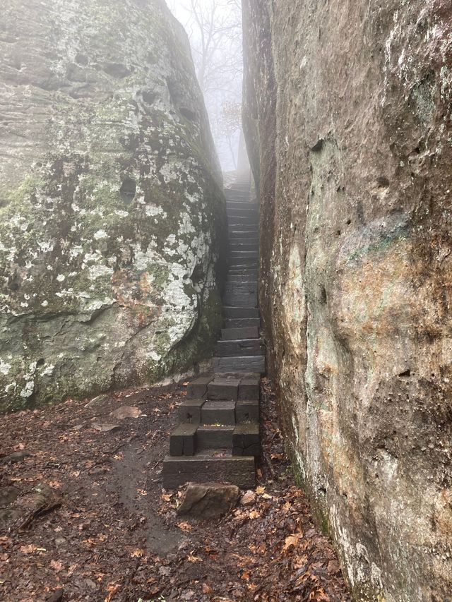 Foggy view of stairs going up between a cut in the rocks on a hike to Black Mountain.