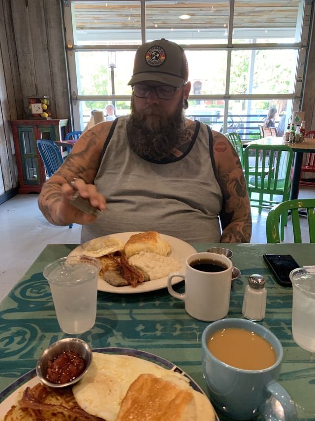 Mike at Sunrise diner, with a serious expression, shaking pepper on his breakfast plate.