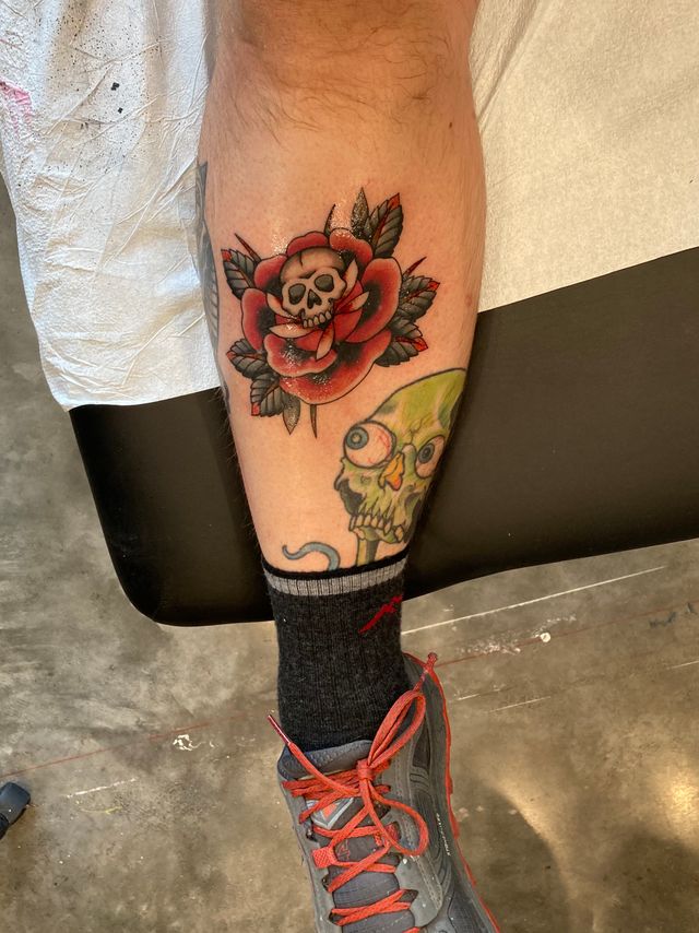 A fresh tattoo on Mikes leg. A red reose with a small skull in the center.