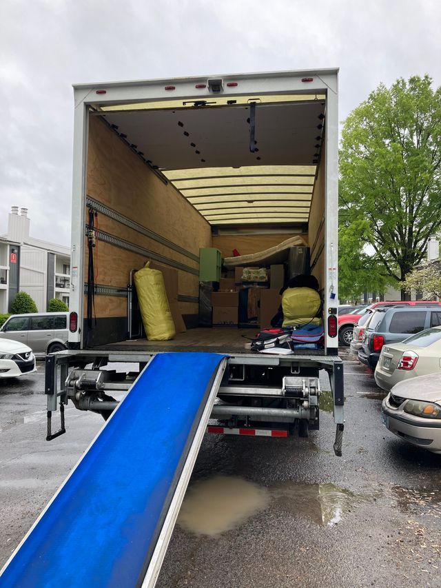 A partially loaded moving truck with a ramp on moving day.
