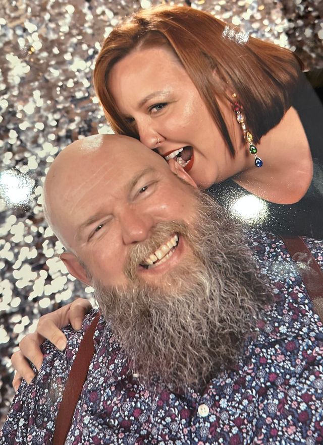 Professional style photo. Rachelle is biting Michael's ear.